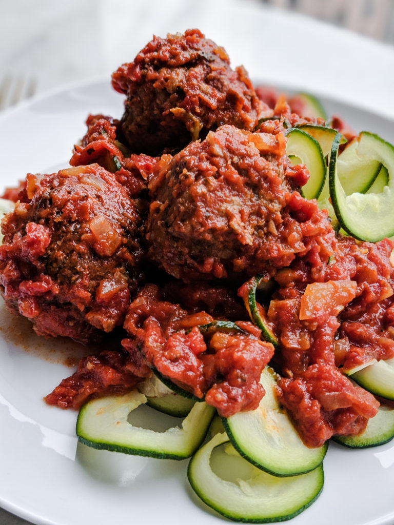 Meatballs with zucchini noodles on plate close up 