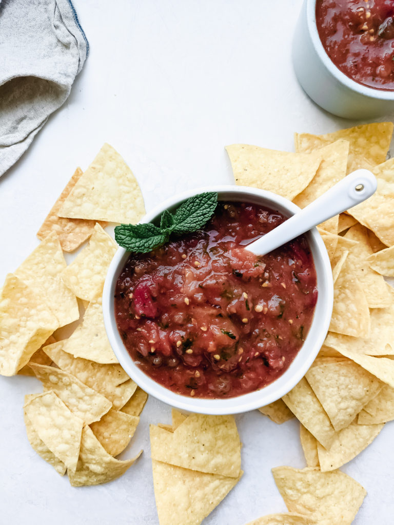 Roasted tomato mint salsa in a small dish with chips surrounding