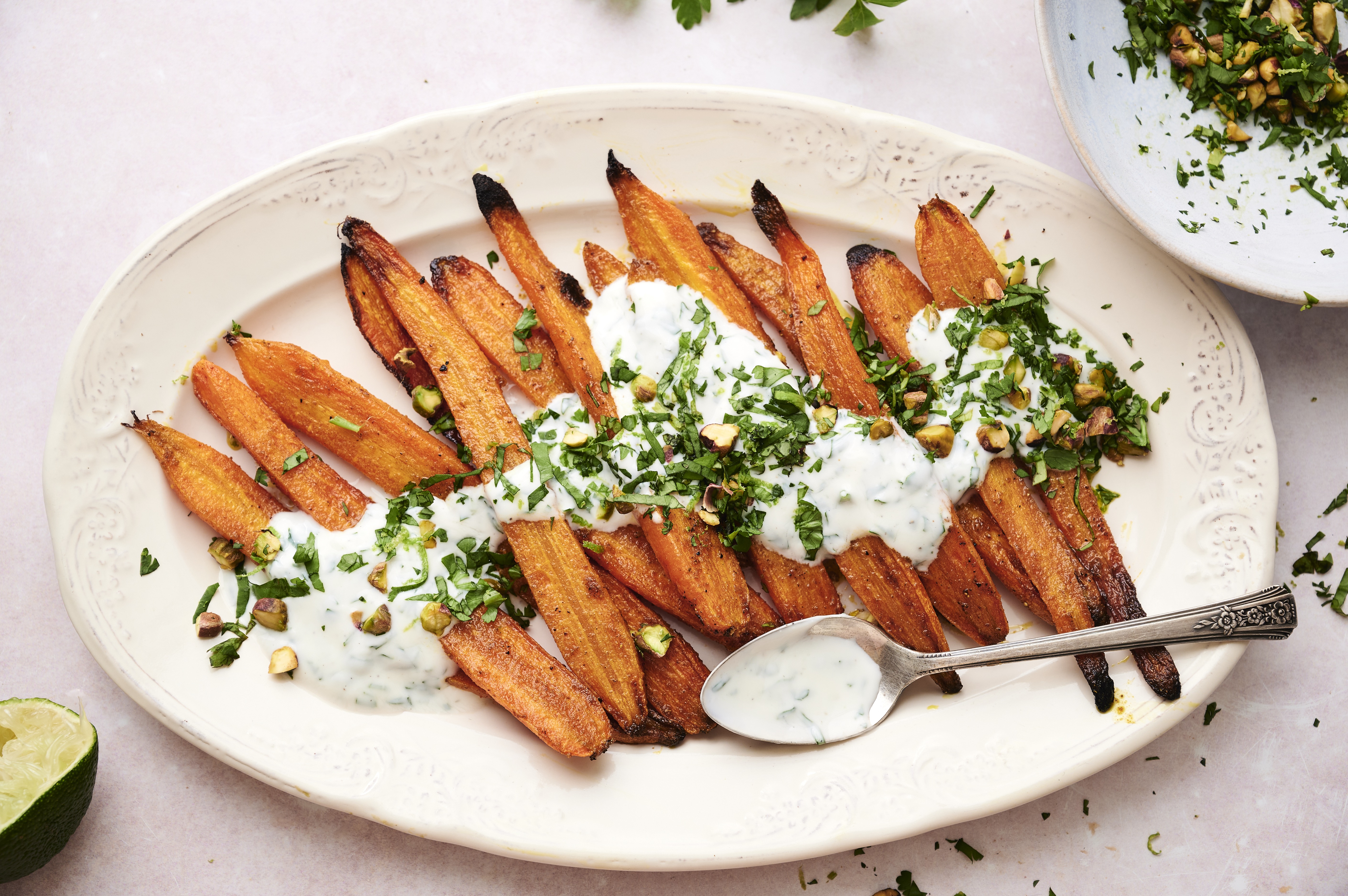 Roasted curry carrots with herb yogurt on a serving plate