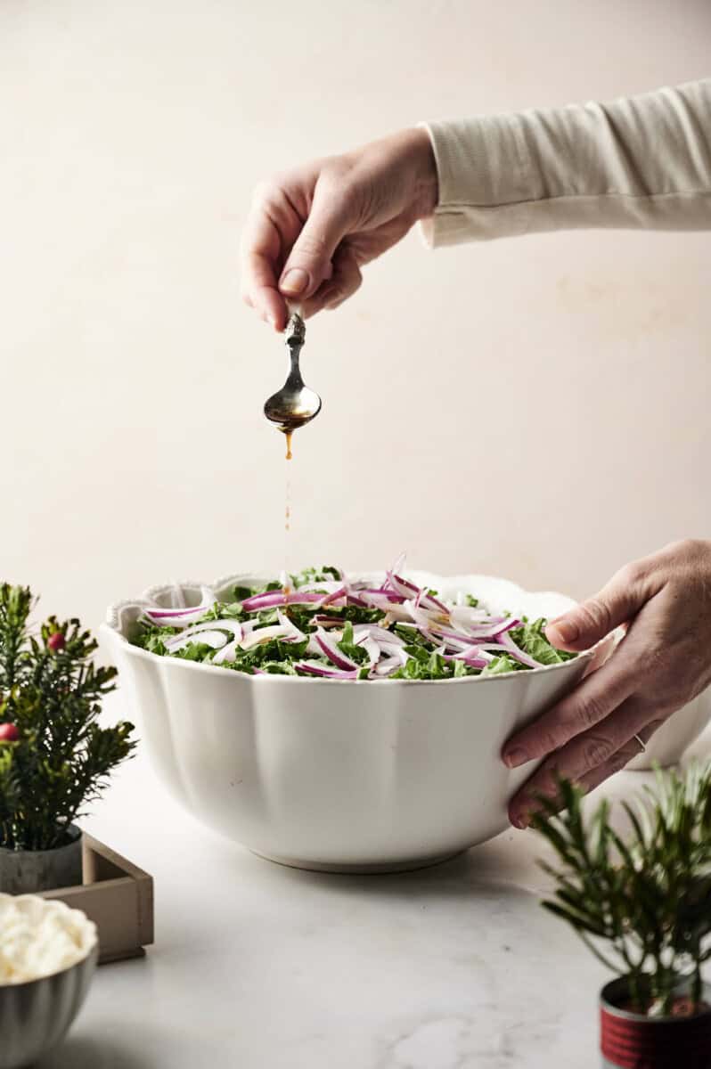 Putting dressing on kale salad