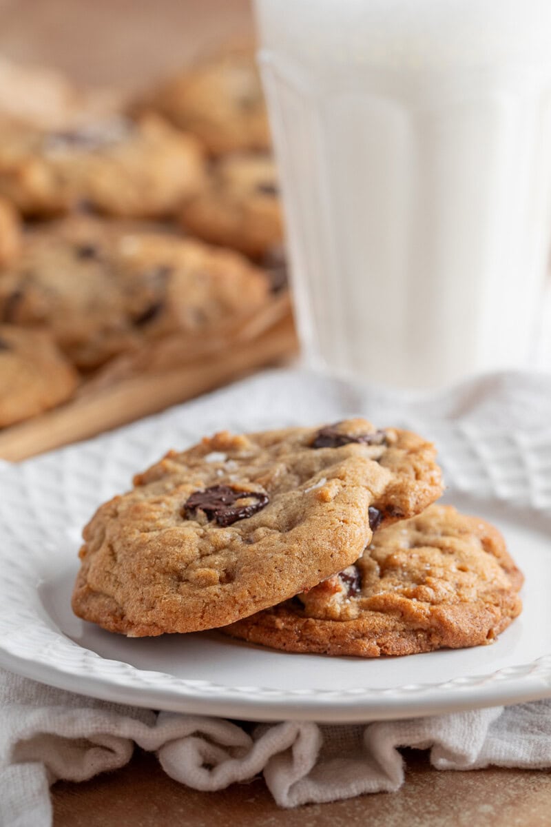 Brown Butter Toffee Chocolate Chunk Cookies on plate with glass of milk 